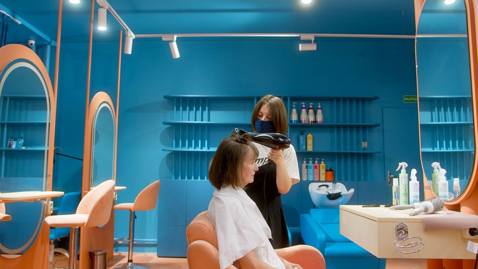A stylist finishing a blow-dry at the Lumière studio window