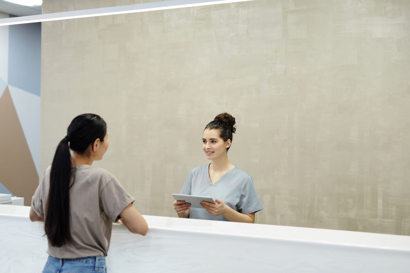 A receptionist welcoming a patient at the Clearview Clinic front desk in Bromley